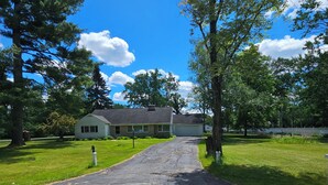 A driveway leading to a house with a garage, surrounded by trees and a clear sky. - Snowmobile Sanctuary in the Charming Village of Crivitz (Crivitz)