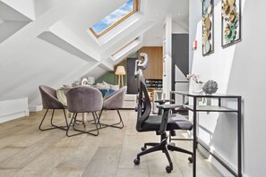 Ein modernes Schlafzimmer im Loft-Stil mit Dachfenster, Schreibtisch und Stuhl.