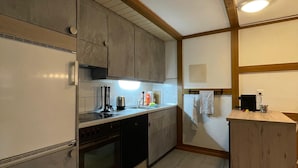 A compact kitchen with a built-in oven, a dishwasher, and a small countertop.