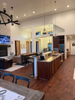 A spacious kitchen with a large island, wooden flooring, and pendant lighting. - Fabulous 5BR Cabin in Torreon with Hot Tub & Huge Deck (Show Low)