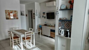 Una cocina moderna con comedor, televisor y elementos decorativos.