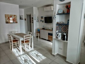 Eine moderne Küche mit Essbereich, Fernseher und Dekorationselementen.