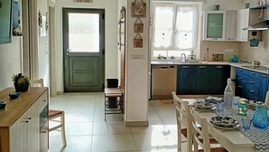 Una cocina amplia con comedor, vistas al exterior y una puerta que da a otra habitación.