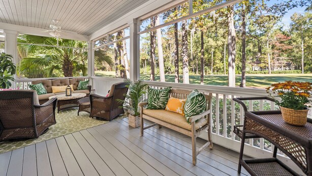 A covered porch with wicker furniture, a cushioned bench, and potted plants. - Callawassie Island Beautiful 3BR/3BA Retreat Free Golf, Riverfront Pools (Okatie)