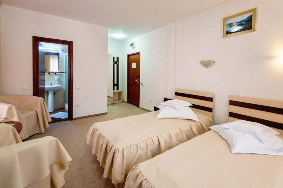 Une chambre d’hôtel avec deux lits, une salle de bain et une table.