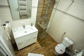A bathroom with a white sink, mirror, and glass shower enclosure. - SUIOR RESORT  (Baia-Sprie)