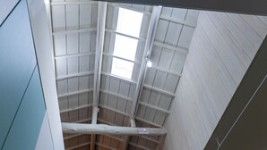 A high ceiling with wooden beams and skylights, a ladder, and a white wall. - Korean Town Front/ Sleeps 8/ 9 Min Walk to Tsuruhashi St/ Direct Access to Namba (Osaka)
