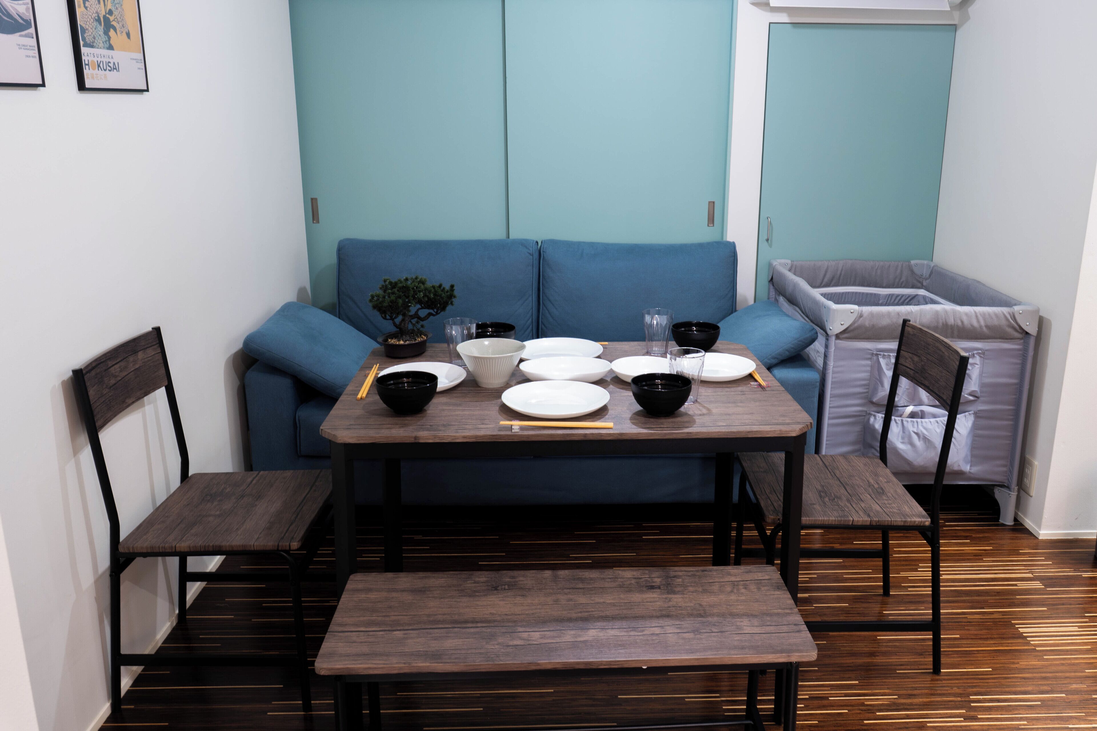 A dining area with a wooden table, blue sofa, and chairs.