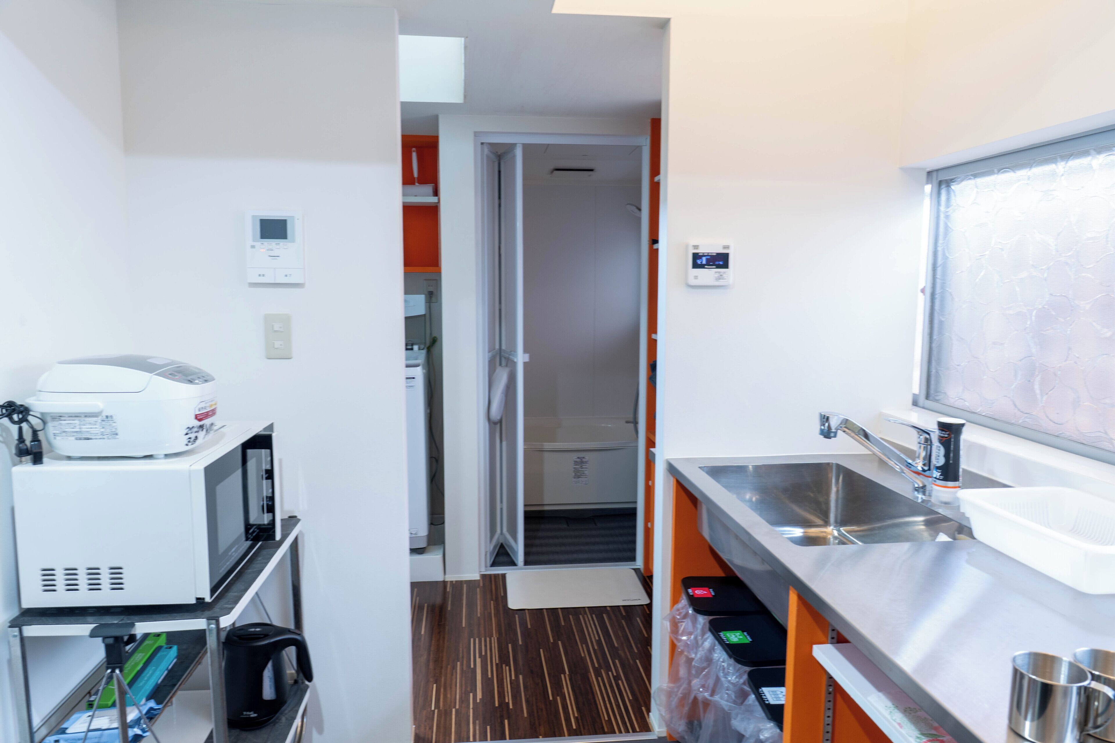 A compact kitchenette with a microwave, coffee maker, and sink.