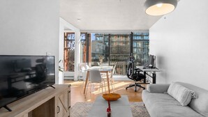 Un soggiorno moderno con televisore, divano, tavolo da pranzo e sedie.