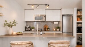 Una cucina moderna con isola centrale, elettrodomestici in acciaio inossidabile e un design minimalista.