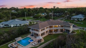 Una amplia casa con piscina, varias terrazas y un césped bien cuidado.