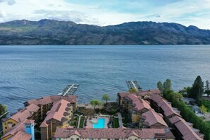 Un hôtel situé au bord d’un lac, doté d’une piscine, de plusieurs bâtiments et surplombant des montagnes.