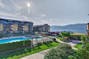 Un complexe résidentiel doté d’une piscine, d’un espace de jeux pour enfants et offrant une vue sur un lac et des montagnes.