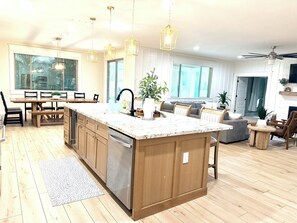 Une cuisine moderne avec des meubles en bois, un lave-vaisselle en acier inoxydable et un plan de travail en granit.