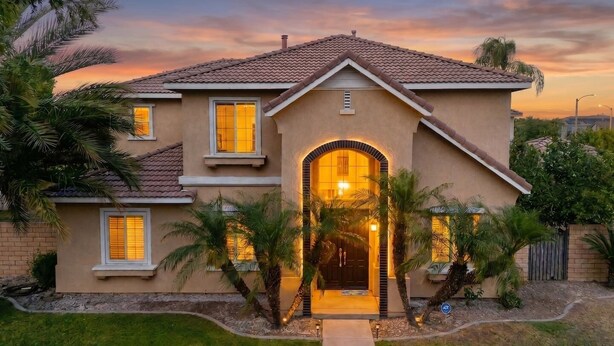 A two-story house with a tiled roof, a central entrance with a door, and a small porch area. - Elegant 5BR Gem @Ontario w/ Grill | Near Airport (Ontario)