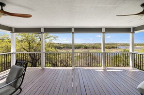 A covered outdoor deck with a view of a natural landscape. - Cozy Lakefront Retreat. Family Friendly w/ Kayaks, Pool Access, Pickleball! (Spicewood)