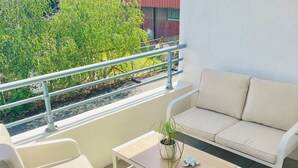 A balcony with a sofa, chairs, a table, and a railing. - T1 bis - Quiet in La Rochelle (La Rochelle)