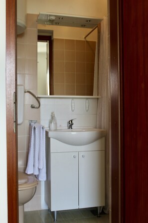 Ein Badezimmer mit Toilette, Waschbecken und Spiegel.