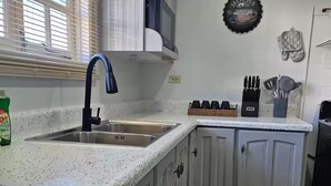 A kitchen with a stainless steel sink, a microwave, and a coffee maker on the countertop.