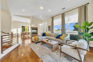 A spacious living room with a sofa, coffee table, and large windows. - Walk to the Shore from This Point Richmond Escape (Richmond)