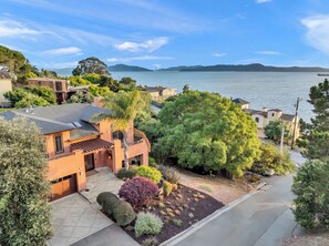 A residential area with houses, a driveway, and a view of the water and bridge. - Walk to the Shore from This Point Richmond Escape (Richmond)