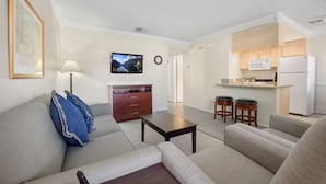 A modern living room with a sofa, coffee table, and a TV on the wall. - Indian Palms Intervals for May (Indio)