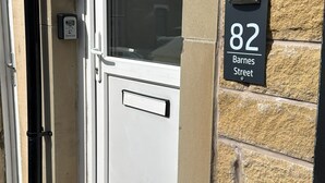 Eine Haustür mit Fenster, Briefkasten und Hausnummer.