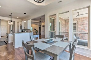 A spacious kitchen with a central island, white cabinetry, and pendant lighting.
