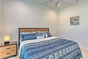 Un dormitori amb un llit, una taula de nit i una obra penjada a la paret.