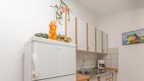 A compact kitchen with a refrigerator, a coffee maker, and a sink. - Villa Estella Adriatic Residence (Vodice)