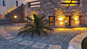 A modern building with stone and concrete architecture, a stone staircase, and a gravel pathway. - PetraCasa: Luxury Sea View Villa with Premium Private Outdoor Spa (Azolimnos)