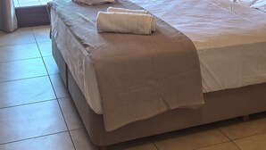 A hotel room with a bed, a view of the sea, and a painting on the wall. - PetraCasa: Luxury Sea View Villa with Premium Private Outdoor Spa (Azolimnos)