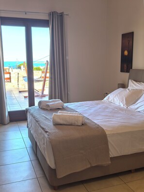 Ein Hotelzimmer mit Bett, Meerblick und einem Gemälde an der Wand.