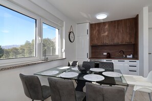 A modern kitchen with a dining area, large windows, and a view of the outdoors. - Apartment Lux 1 near the Sea with Balcony (Starigrad)