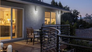 Eine überdachte Terrasse mit Esstisch, Stühlen und Geländer.
