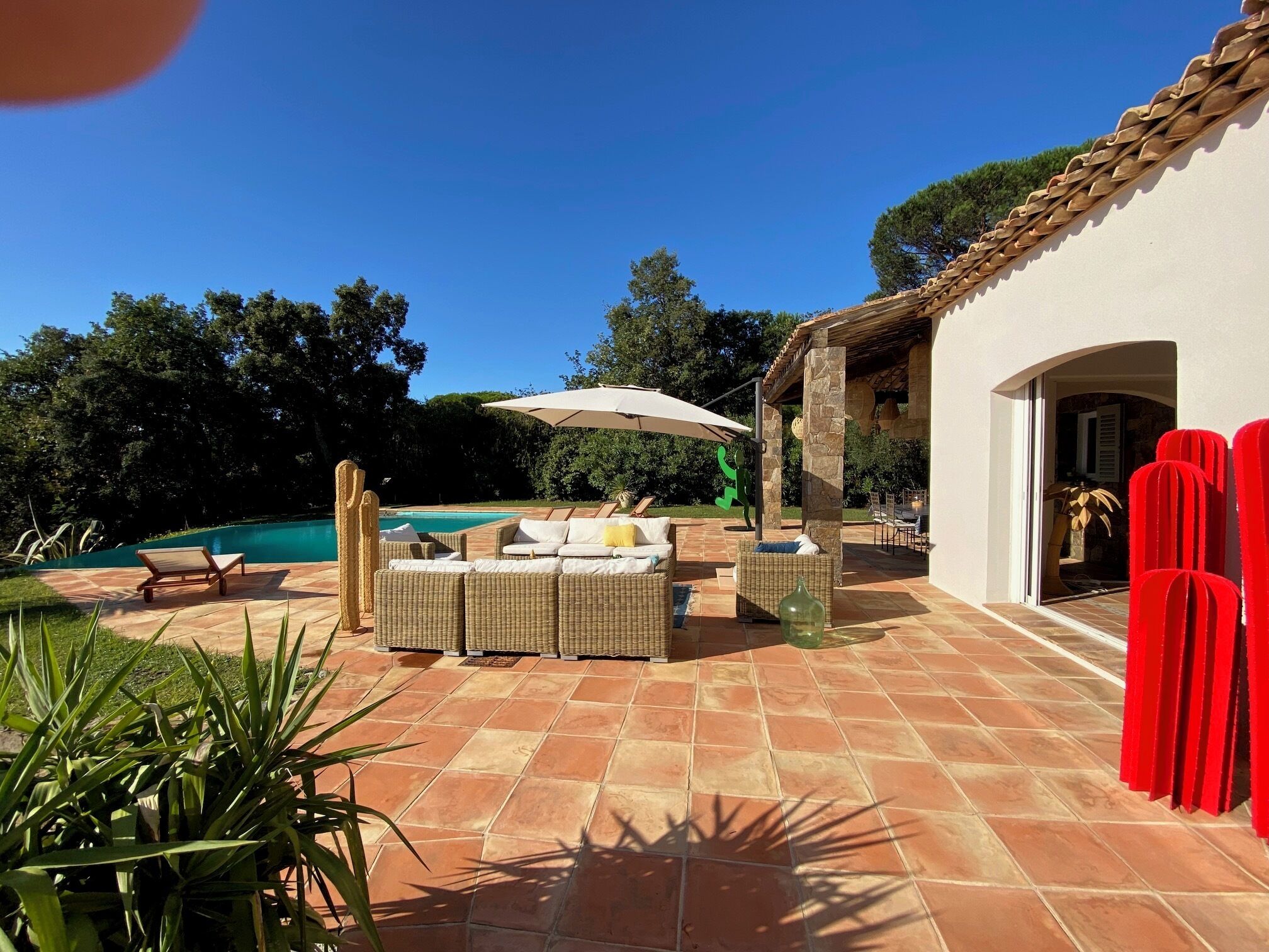 A patio area with outdoor furniture, a pool, and a covered seating area.