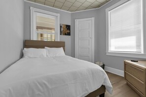 Ein Schlafzimmer mit einem Bett, einem Schminktisch und einer Tür.