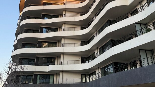 A multi-story building with curved balconies and a modern architectural design.