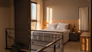A modern bedroom with a large bed, a bedside table, a nightstand, a window with curtains, and a staircase with a railing. - Exclusive Loft | Rooftop with Panoramic Views (São Raimundo Nonato)