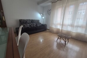Ein Wohnzimmer mit einer Couch, einem kleinen runden Tisch und einem Glastisch.