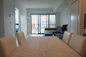 Ein modernes Hotelzimmer mit einem großen Bett, einer Couch und einem Balkon mit Blick.