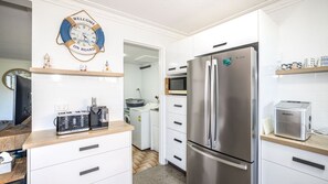 Eine moderne Küche mit einem Edelstahl-Kühlschrank, einer Kaffeemaschine und einer Mikrowelle.