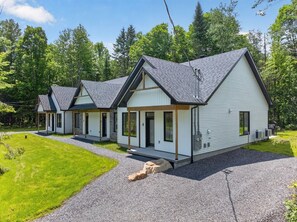 En rad moderna, enplansstugor med en grusuppfart och en gräsplätt.