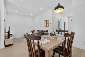 Un comedor con mesa de madera, sillas e iluminación colgante.