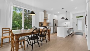 A modern kitchen with white cabinets, a central island, and pendant lighting. - Le Relais Austin - Full Property (4 Units-6 beds) (Austin)