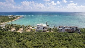 Ein Küstenhotel mit mehreren Gebäuden, einem Steg und einem Strand.