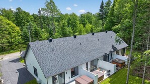 A modern house with a large deck, a covered patio, and a garage.