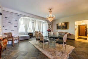 A dining area with a glass table, chairs, and a chandelier. - Charming 1BR Apartment in Shkodër City Center by PikHost (Shkodër)