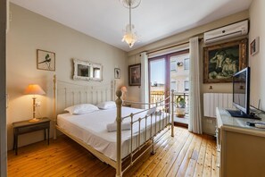 A bedroom with a bed, bedside lamp, dresser, and a balcony with a view. - Charming 1BR Apartment in Shkodër City Center by PikHost (Shkodër)